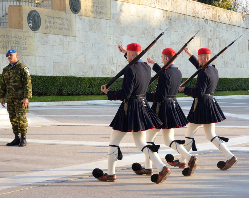 Evzones, elite ceremonial soldiers of the Hellenic Presidential Guard, marching in traditional uniforms in front of the Tomb of the Unknown Soldier at Syntagma Square in Athens